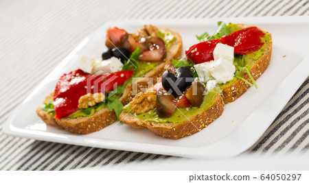 Sandwich with vegetables, walnut and feta cheese at plate 64050297