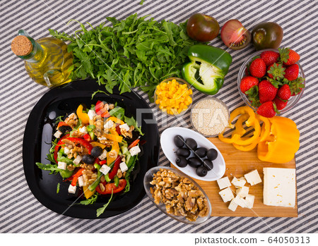 Salad with arugula, olives, Feta cheese, corn and walnut and its ingredients 64050313