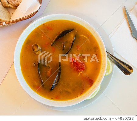 Delicious seafood soup with mussels and prawns served 64050728