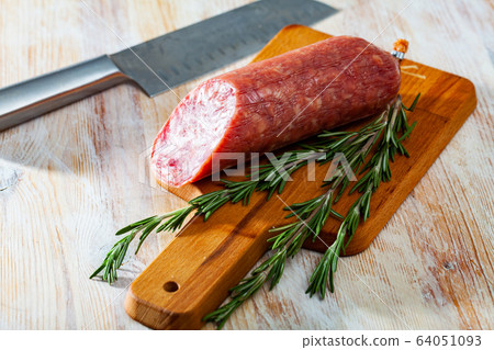 Appetizing salchichon sausage on wooden table 64051093