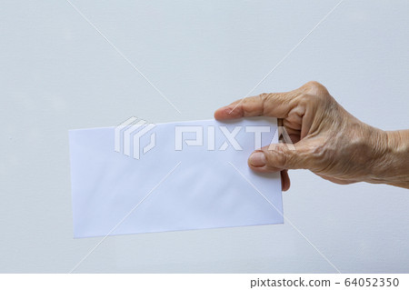Senior woman's right hand holding white envelope or bride isolated on white background, Close up and macro shot, Business concept 64052350