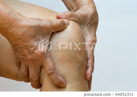 Senior woman suffering from right knee pain, Massaging by her hand in white background, Close up & Macro shot, Asian body skin part, Healthcare, About Massage concept 64052351