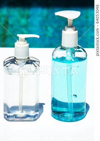 People's hands using portable wash hand sanitizer gel pump dispenser with alcohol gel sanitizer on white & blue, Close up shot, Prevention from covid19, Bacteria, Healthcare, 7 step wash hand 64053048