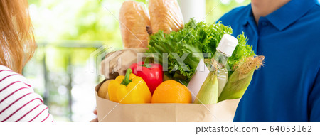 Grocery delivery man delivering food to a woman at home 64053162