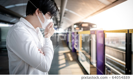 Asian man wearing mask at skytrain station 64054889