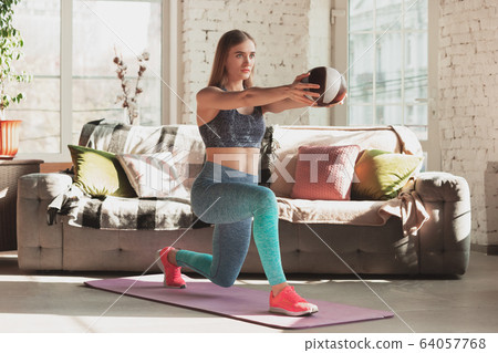 Young woman teaching at home online courses of fitness, aerobic, sporty lifestyle while being quarantine Young woman teaching at home online courses of fitness, aerobic, sporty lifestyle while being quarantine 64057768