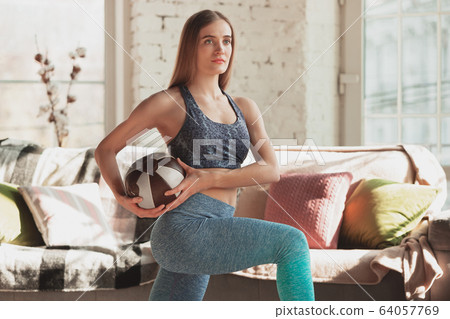 Young woman teaching at home online courses of fitness, aerobic, sporty lifestyle while being quarantine Young woman teaching at home online courses of fitness, aerobic, sporty lifestyle while being quarantine 64057769