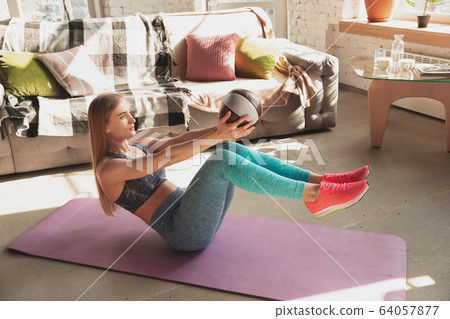 Young woman teaching at home online courses of fitness, aerobic, sporty lifestyle while being quarantine Young woman teaching at home online courses of fitness, aerobic, sporty lifestyle while being quarantine 64057877