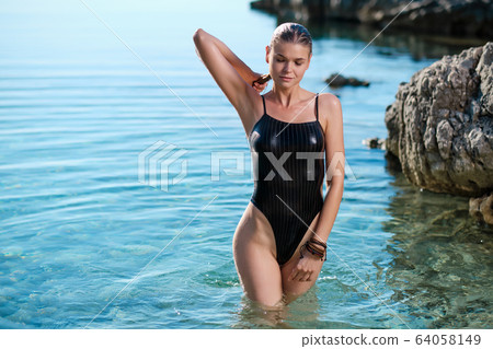 Sexy beautiful woman standing in the water. Sexy beautiful woman standing in the water. 64058149
