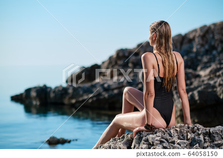 beautiful woman on the stones beach. caucasian beautiful woman on the stones beach. caucasian 64058150