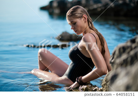 beautiful woman on the stones beach. caucasian beautiful woman on the stones beach. caucasian 64058151