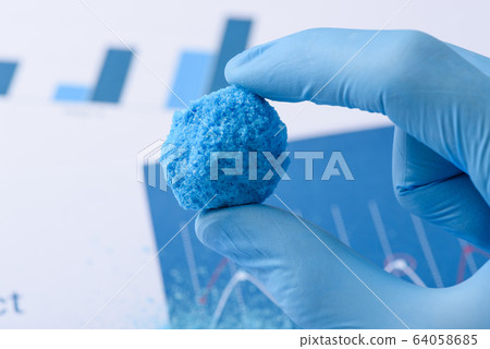 Big blue chemical crystal in scientist hands in laboratory 64058685