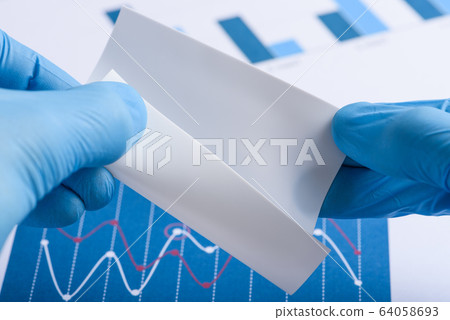 Scientist show white semi transparent layer of novel flexible material in laboratory Scientist show white semi transparent layer of novel flexible material in laboratory 64058693