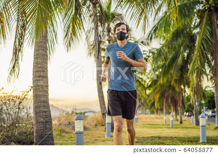 Runner wearing medical mask, Coronavirus pandemic Covid-19. Sport, Active life in quarantine Runner wearing medical mask, Coronavirus pandemic Covid-19. Sport, Active life in quarantine 64058877