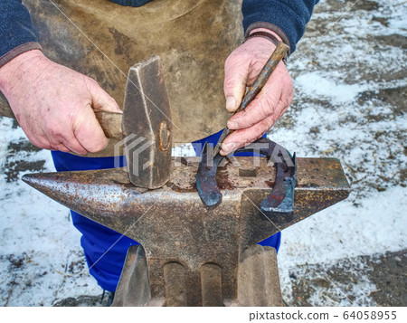 Finalize horseshoe, hitting hot metal with hammer Finalize horseshoe, hitting hot metal with hammer 64058955