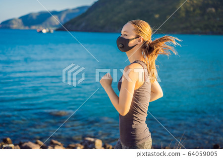 Runner wearing medical mask, Coronavirus pandemic Covid-19. Sport, Active life in quarantine Runner wearing medical mask, Coronavirus pandemic Covid-19. Sport, Active life in quarantine 64059005