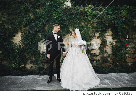 Wedding couple holding hands, groom and bride together on wedding day Wedding couple holding hands, groom and bride together on wedding day 64059333