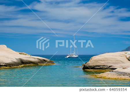 Yacht boat at Sarakiniko Beach in Aegean sea, Milos island , Greece 64059354