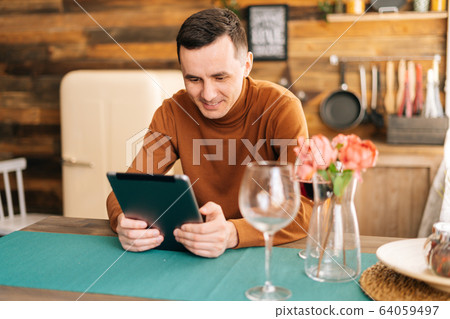 Young happy man online communication with digital tablet. Young happy man online communication with digital tablet. 64059497