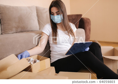 Woman in quarantine wearing protective mask at home and buying online. Coronavirus concept. Stay Home 64059803