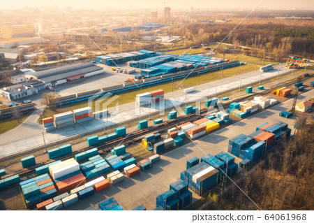 Aerial view of container loading and unloading at sunset. Top view of containers Aerial view of container loading and unloading at sunset. Top view of containers 64061968
