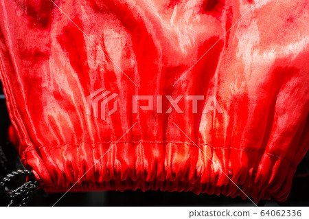 Dry Polyester Tote Bag in the sun, Red glossy texture backgroud, Close up & macro shot, Sport  bag concept 64062336