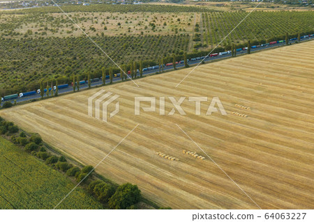 Trucks driving through the countryside. Aerial view from drone. Cargo driving 64063227
