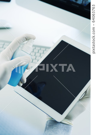 man disinfecting his digital tablet man disinfecting his digital tablet 64063763