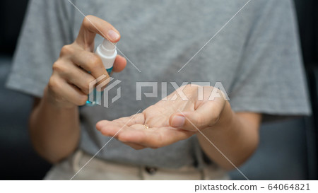 Hand applying spray bottle for hand wash sanitizer Hand applying spray bottle for hand wash sanitizer 64064821