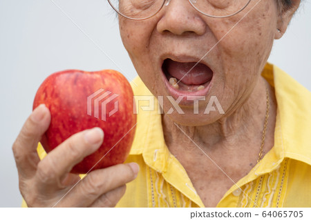 An old woman wears glasses and without teeth 64065705