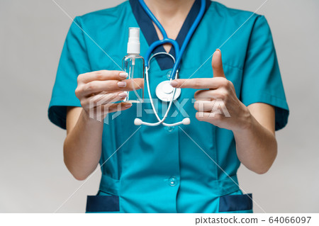 medical doctor nurse wearing protective mask - holding bottle of sanitizing spray or gel medical doctor nurse wearing protective mask - holding bottle of sanitizing spray or gel 64066097