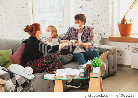 Caucasian family in protective masks and gloves isolated at home with coronavirus symptoms, treatment Caucasian family in protective masks and gloves isolated at home with coronavirus symptoms, treatment 64066235