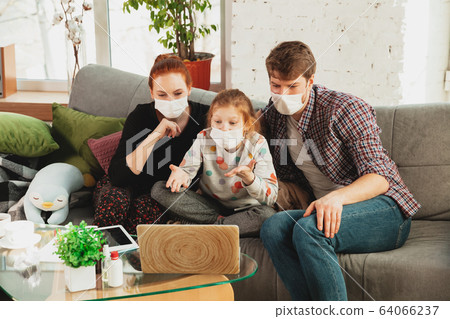 Caucasian family in protective masks and gloves isolated at home with coronavirus symptoms, treatment 64066237