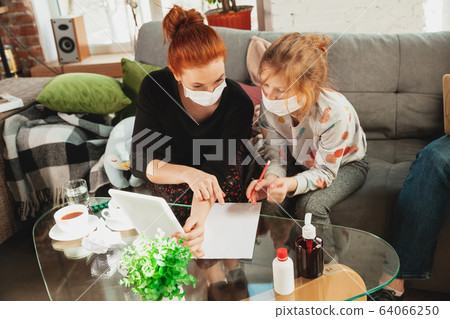 Mother and daughter in protective masks and gloves isolated at home with coronavirus symptoms, stop epidemic 64066250