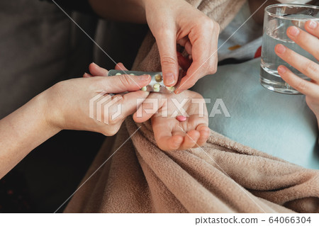 Close up shoot of mother giving pills for little daughter feeling sick with coronavirus symptopms in mild condition Close up shoot of mother giving pills for little daughter feeling sick with coronavirus symptopms in mild condition 64066304