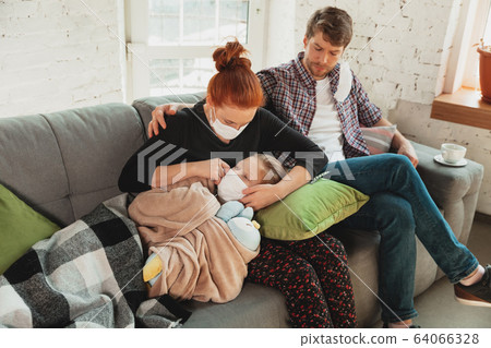 Caucasian family in protective masks and gloves isolated at home with coronavirus symptoms, treatment 64066328
