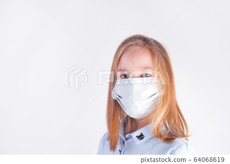 Beautiful young girl in a medical protective mask against light grey background. 64068619