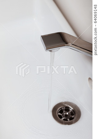 Water flows from the tap. Home bathroom 64069148