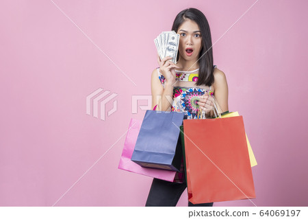 Portrait of young woman showing money with WOW 64069197