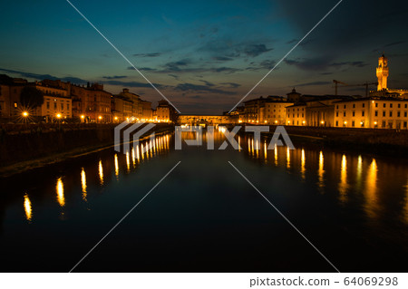 Florence, Italy - 2020. View of medieval stone bridge Ponte Vecchio and the Arno River from the Ponte Santa Trinita. Florence, Italy - 2020. View of medieval stone bridge Ponte Vecchio and the Arno River from the Ponte Santa Trinita. 64069298