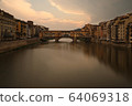 Florence, Italy - 2020. View of medieval stone bridge Ponte Vecchio and the Arno River from the Ponte Santa Trinita. 64069318