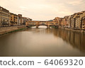 Florence, Italy - 2020. View of medieval stone bridge Ponte Vecchio and the Arno River from the Ponte Santa Trinita. 64069320