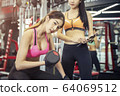 Beautiful sport woman working out with dumbbell 64069512