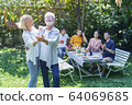 Senior couple dancing together with family in 64069685