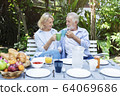 Senior couple having lunch in garden with happy. 64069686