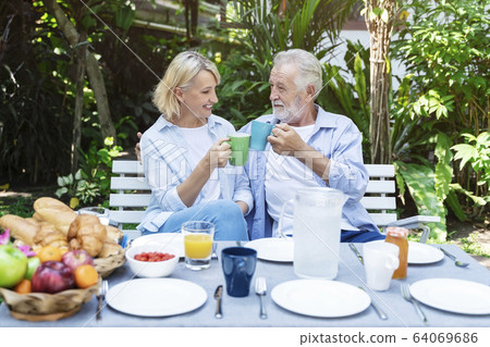 Senior couple having lunch in garden with happy. Senior couple having lunch in garden with happy. 64069686
