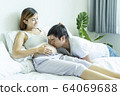 Husband kissing his wife’s belly in bed. Pregnant 64069688