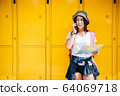 Young traveller holding a map and using mobile to 64069718