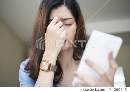 Young woman using smartphone tired rubbing nose Young woman using smartphone tired rubbing nose 64069843