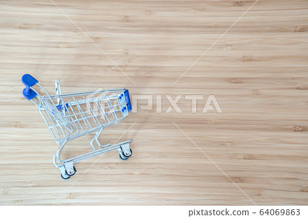 Shopping cart on wheatered wood background. Shopping cart on wheatered wood background. 64069863